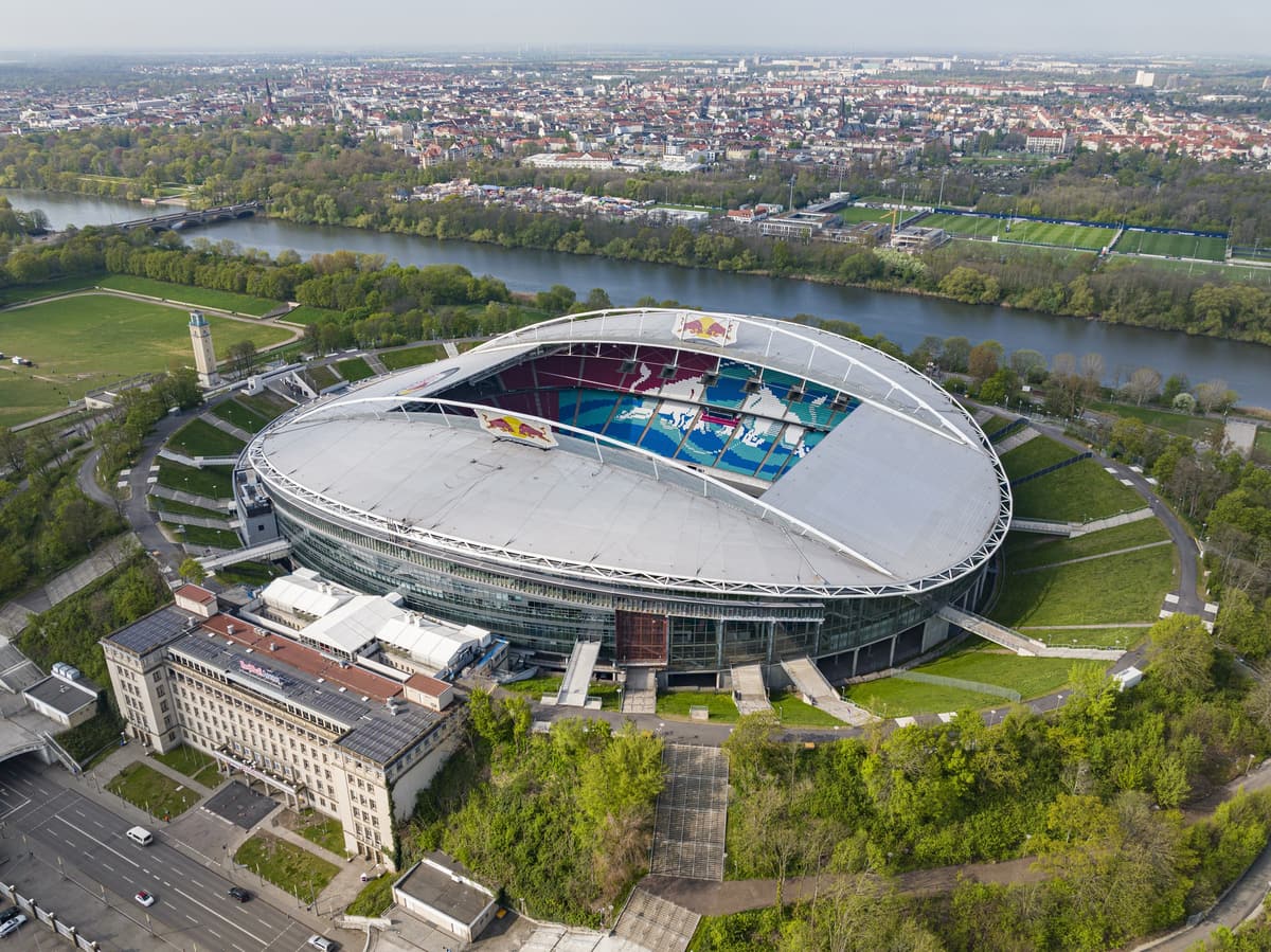 Luftbild der Red Bull Arena in Leipzig mit dem Elsterbecken und der Stadt im Hintergrund.